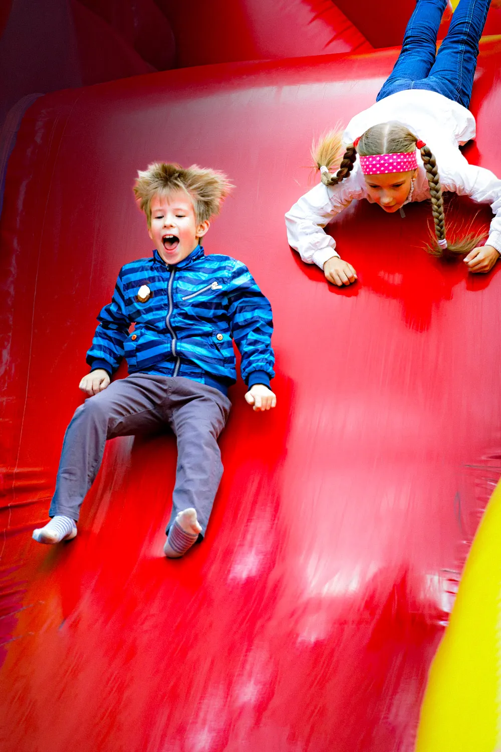 Children enjoying an inflatable slide at a One Party Rental event